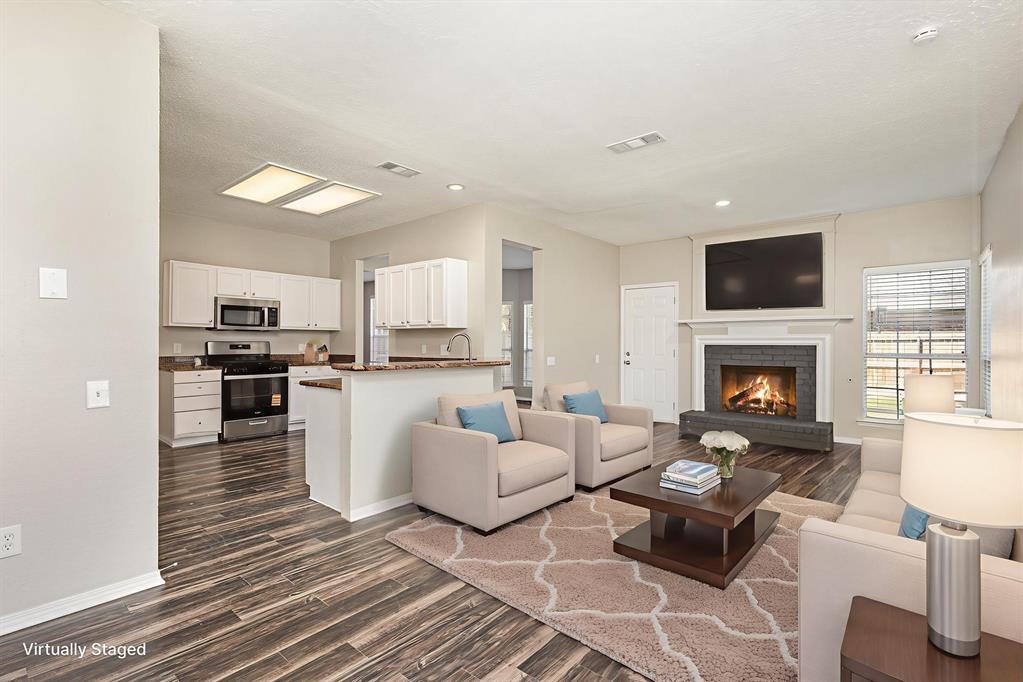 7100 Layla Road Arlington, TX 76016 - Photo 3 of 19 Virtually staged-Living area featuring dark wood-style floors and a brick fireplace