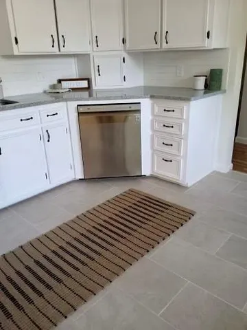 a backyard of a house with table and chairs under an umbrella