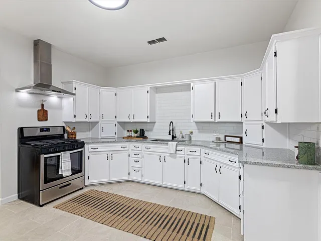 a kitchen with granite countertop white cabinets and white appliances