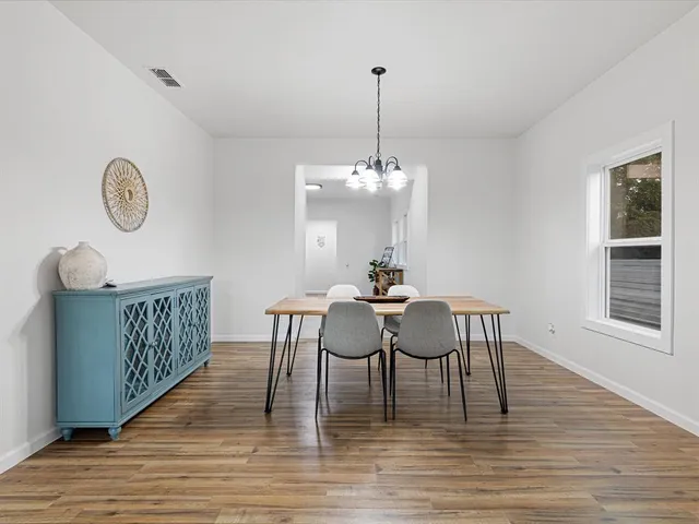 a dining room with furniture a chandelier and wooden floor