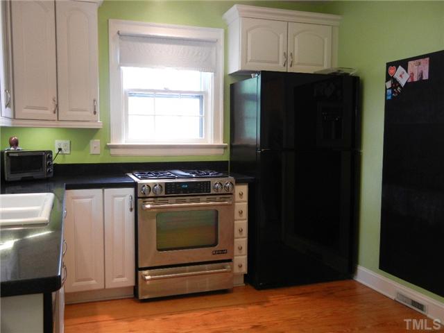 601 Harding Street Raleigh, NC 27604 - Photo 4 of 24 a kitchen with granite countertop white cabinets and black appliances