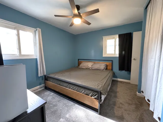 a bed sitting in a bedroom next to a window