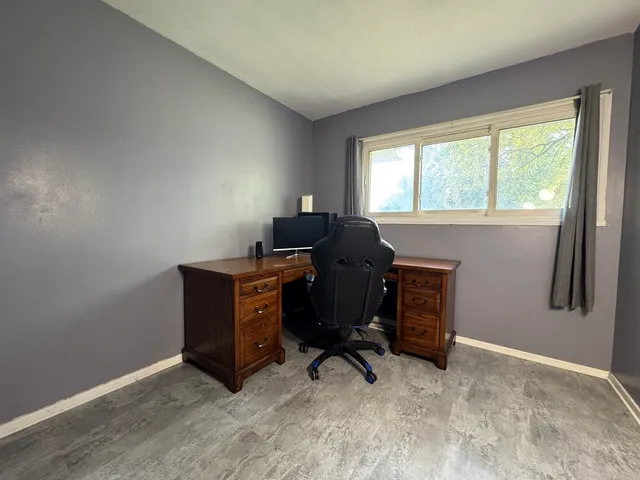 a view of a workspace with furniture and a window