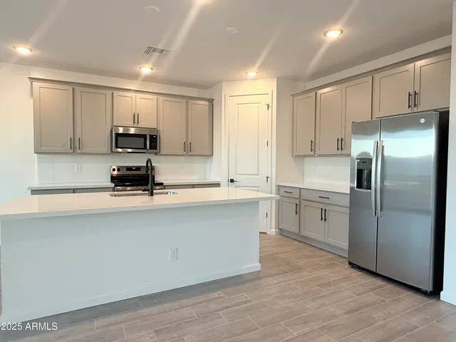 a kitchen with stainless steel appliances a refrigerator sink and microwave
