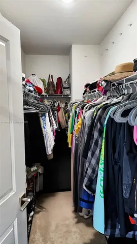 a view of walk in closet with clothes