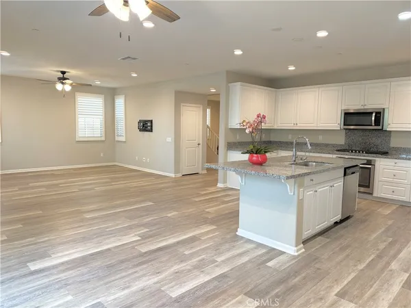 an open kitchen with white cabinets and sink