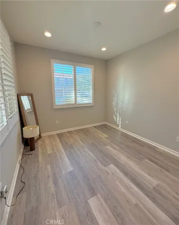an empty room with wooden floor and a window