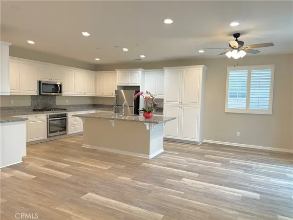a living room with stainless steel appliances kitchen island granite countertop furniture and a view of kitchen