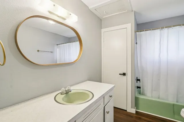 a bathroom with a granite countertop sink and a mirror