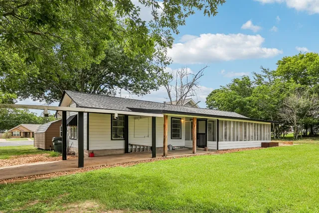 a view of a house with backyard and porch