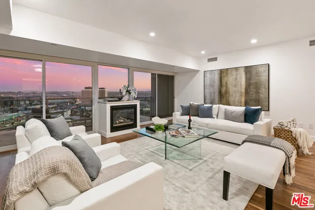 a living room with furniture fireplace and a large window