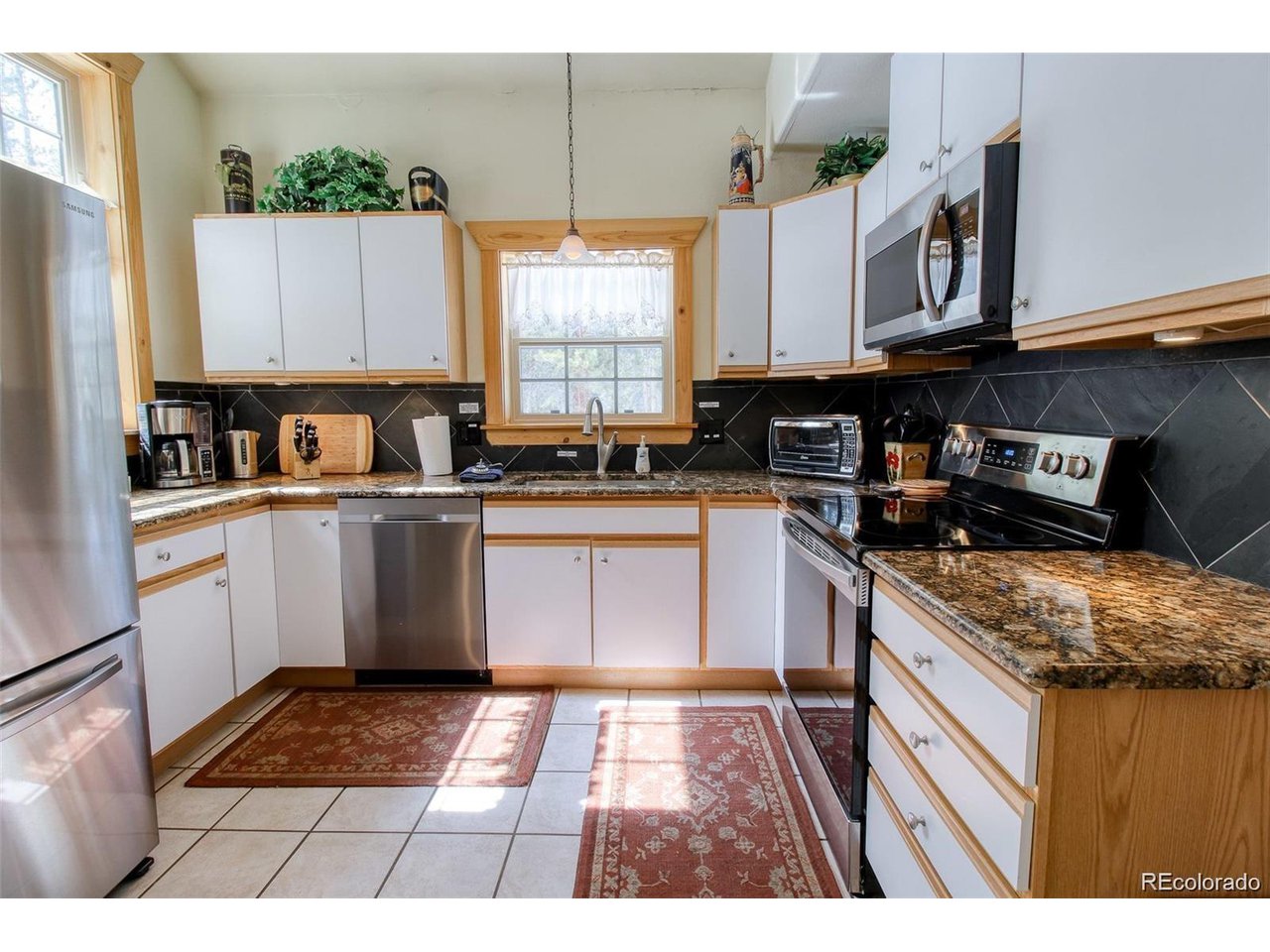 4 Lost Mine Loop, Unit 4B Leadville, CO 80461 - Photo 5 of 16 a kitchen with stainless steel appliances granite countertop a stove a sink and a microwave