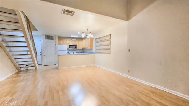 a view of a kitchen with wooden floor and electronic appliances
