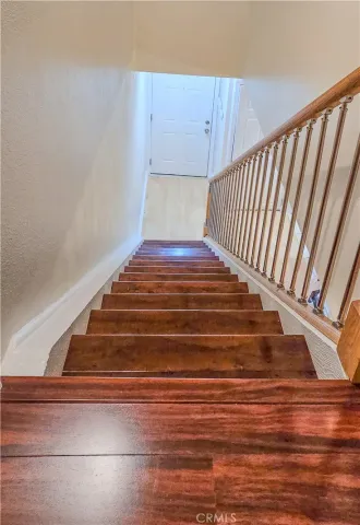 a view of staircase with wooden floor and white walls