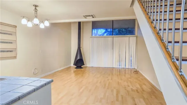 a view of a hallway with wooden floor and a bathroom