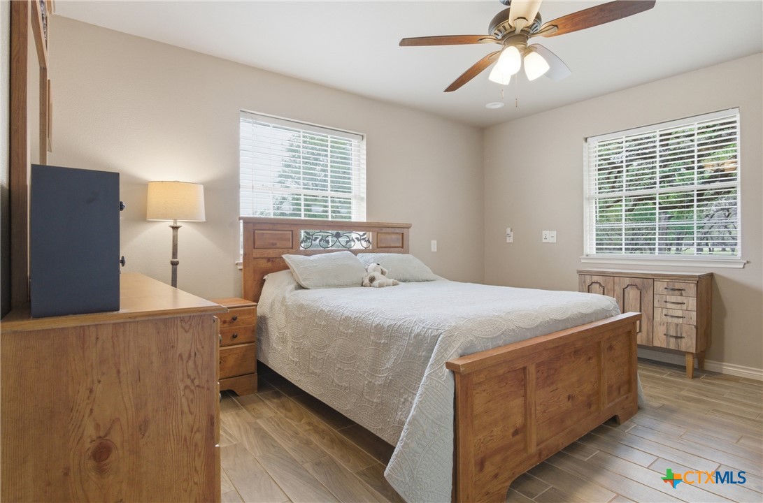 642 Phantom Rider Trail Spring Branch, TX 78070 - Photo 41 of 41 a bedroom with a bed and a chandelier