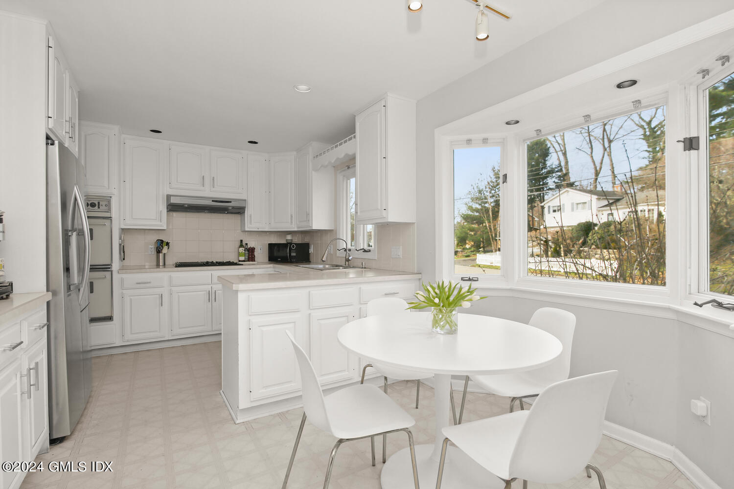 38 Amherst Road Riverside, CT 06878 - Photo 3 of 22 a kitchen with stainless steel appliances white cabinets a table and chairs in it