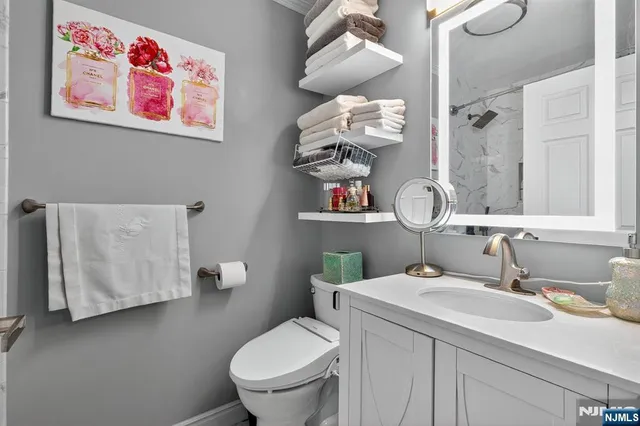 a bathroom with a sink mirror vanity and toilet