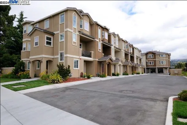 a front view of residential houses with yard and green space