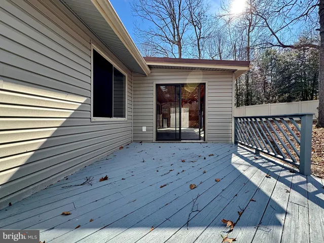 a view of an empty room with wooden floor and windows