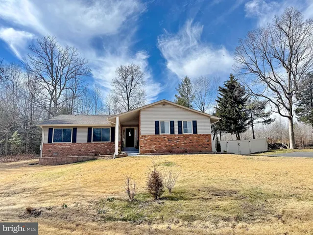 a front view of a house with a yard covered with snow