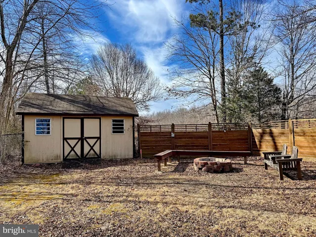 an empty room with wooden floor fireplace and cabinet