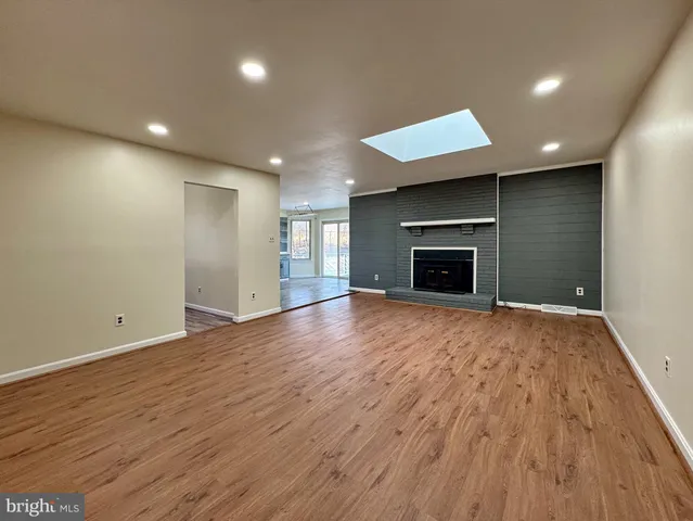 an empty room with chandelier fan and windows