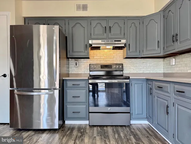 an empty room with windows and ceiling fan