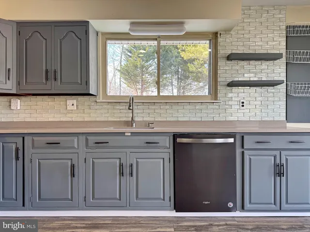 a view of empty room with wooden floor and ceiling fan