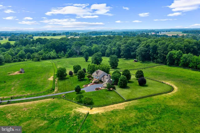 a view of a green field with wooden fence