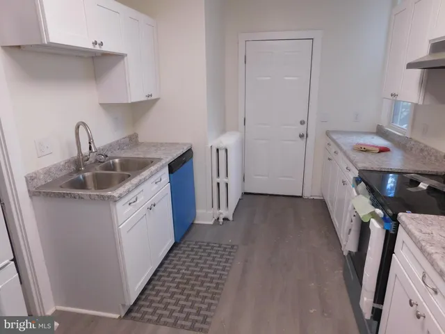 a kitchen with a sink a refrigerator and cabinets
