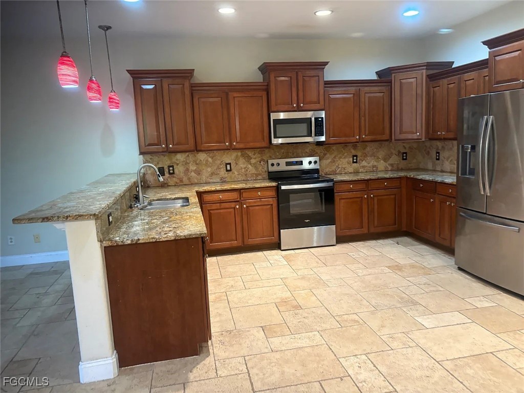12398 Rock Ridge Lane Fort Myers, FL 33913 - Photo 14 of 43 a kitchen with stainless steel appliances granite countertop a refrigerator sink and stove