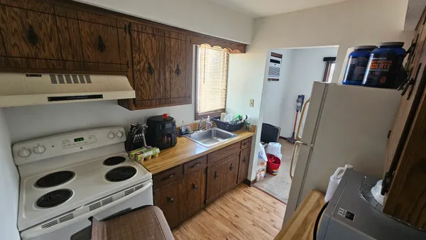 a kitchen with a refrigerator a stove a sink and a cabinets