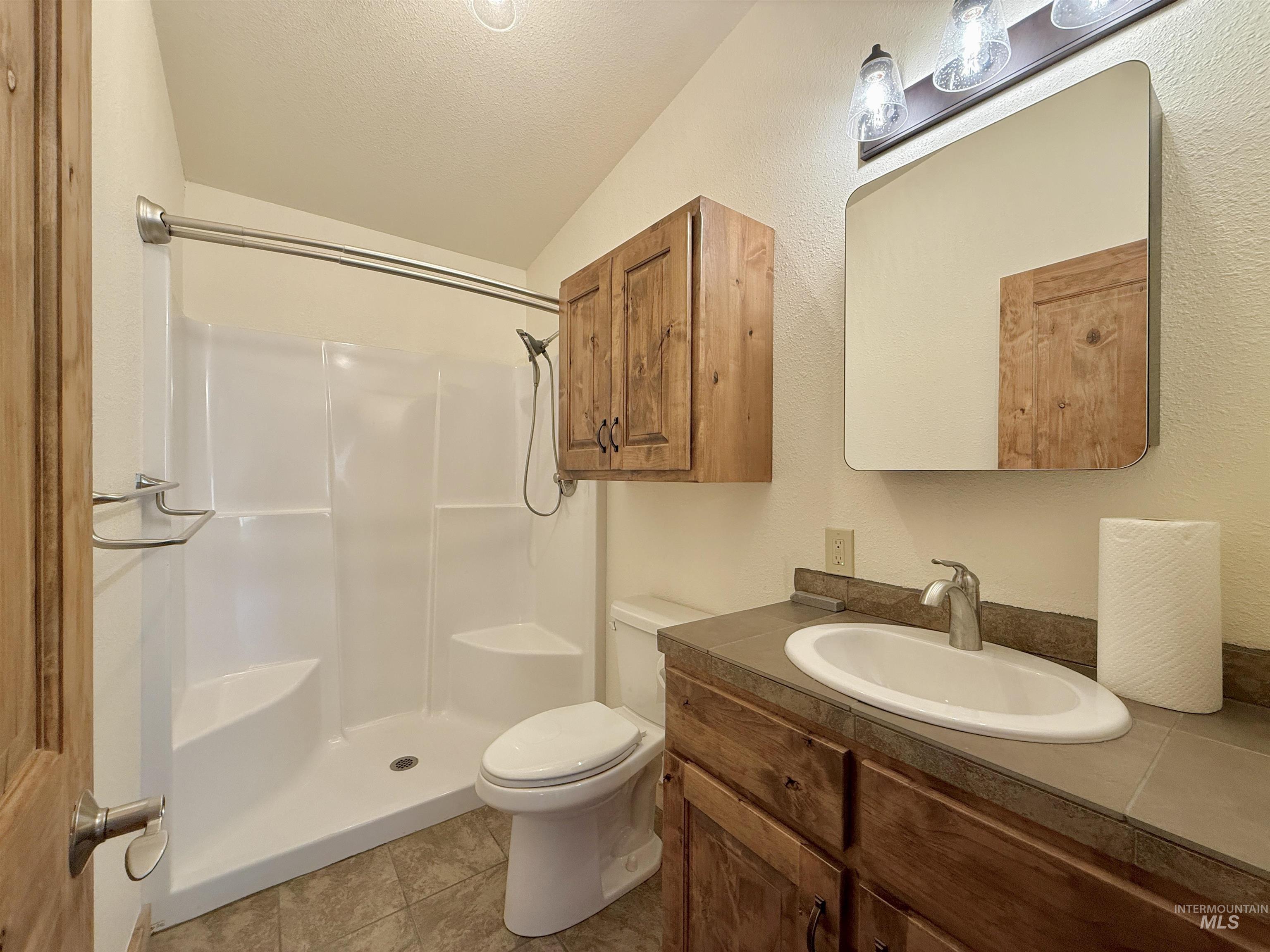 150 Buck Boulevard White Bird, ID 83554 - Photo 14 of 45 Full bath featuring a textured ceiling, vanity, a shower, and tile patterned floors