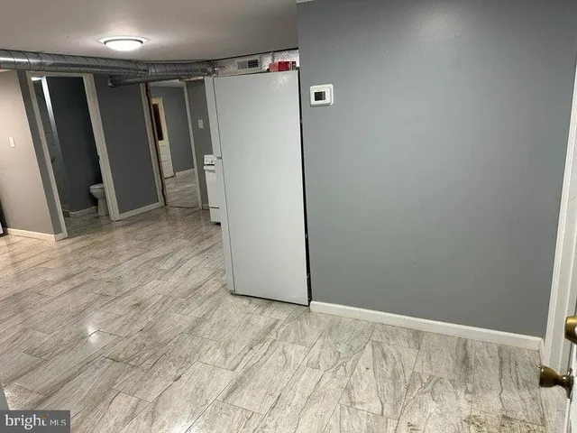 a view of an empty room with a fireplace and a window