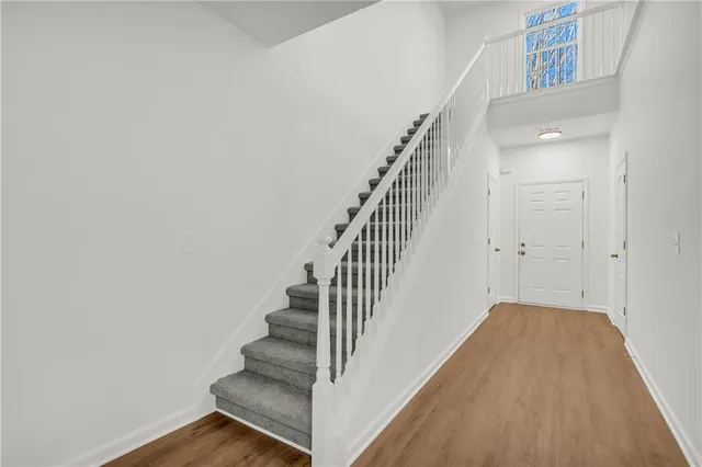 an empty room with windows and chandelier fan