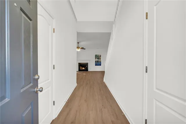 an empty room with windows chandelier and fireplace