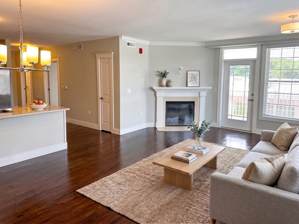 978 Worcester Street, Unit 310 Wellesley, MA 02482 - Photo 2 of 8 a living room with furniture and a fireplace