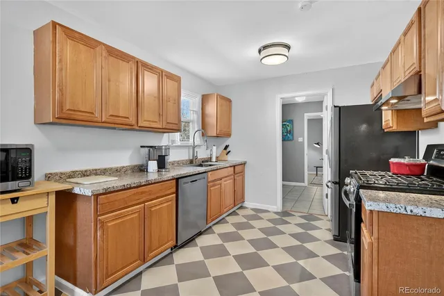 a kitchen with stainless steel appliances granite countertop a stove a sink and a refrigerator