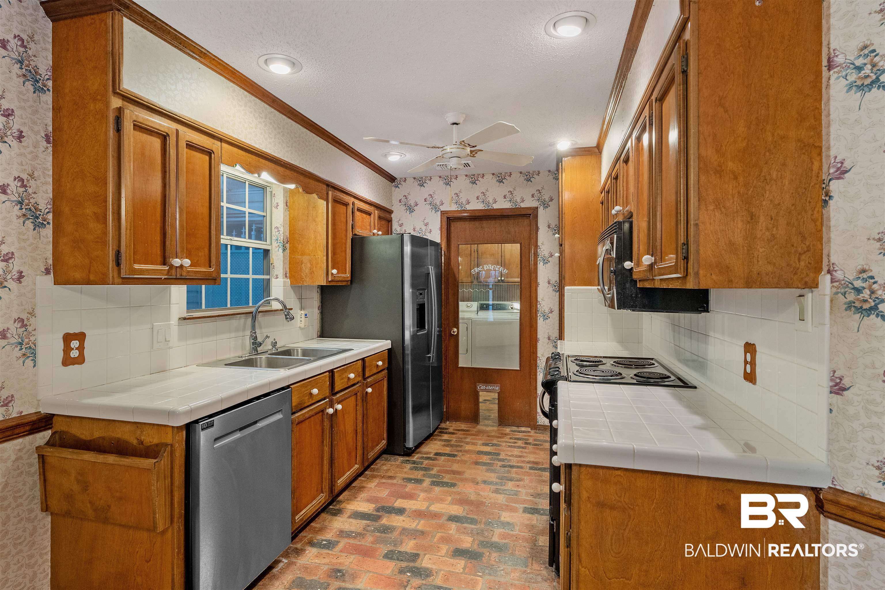 438 Ridgewood Drive Daphne, AL 36526 - Photo 10 of 28 Kitchen with ceiling fan, ornamental molding, sink, stainless steel appliances, and tile countertops