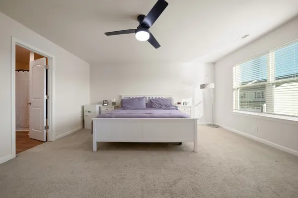 a room with a bed and a ceiling fan