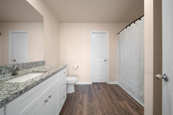 a bathroom with a granite countertop sink toilet and shower
