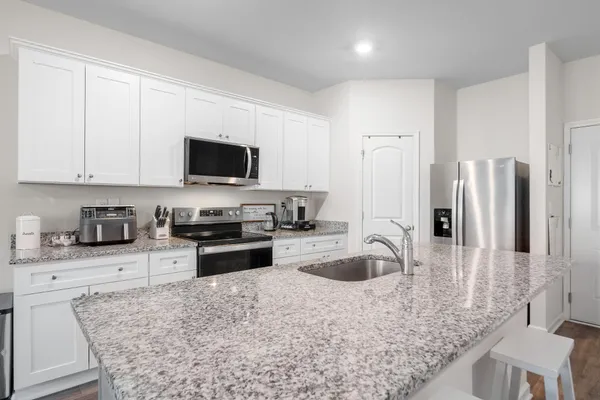 a kitchen with stainless steel appliances granite countertop a sink stove and refrigerator