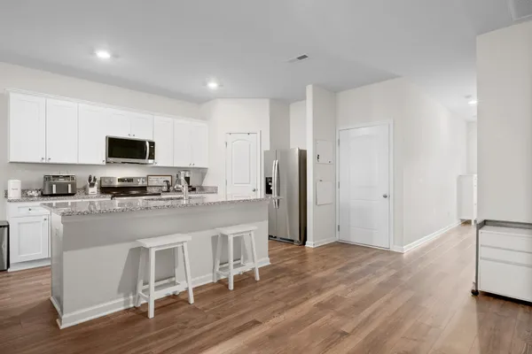 a kitchen with stainless steel appliances granite countertop a refrigerator and a stove top oven