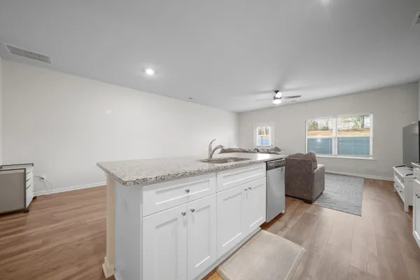 a large kitchen with a lot of counter space and wooden floor