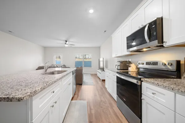 a large kitchen with stainless steel appliances granite countertop a sink and stove top oven