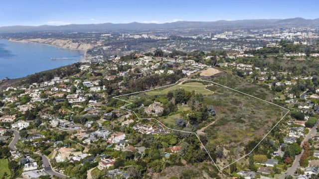 an aerial view of house with yard and mountain view in back