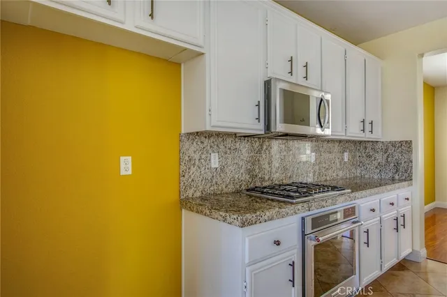 a kitchen with white cabinets and a stove top oven
