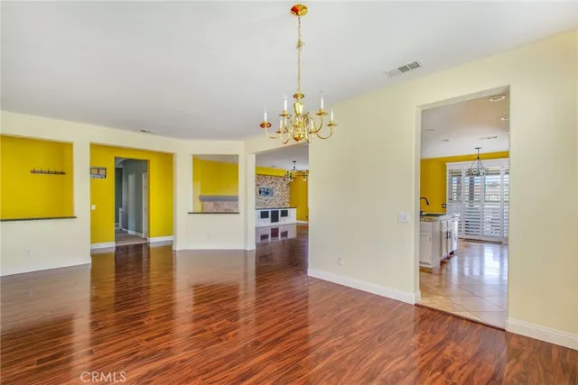 a view of a livingroom with wooden floor and a chandelier