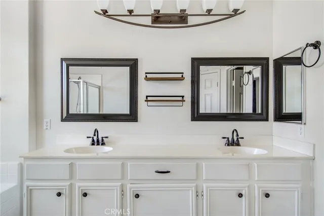 a bathroom with double sink and a mirror